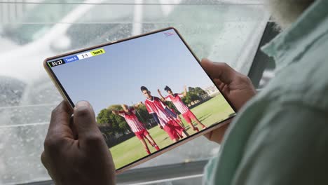 Video-Einer-Person,-Die-Auf-Der-Couch-Sitzt-Und-Sich-Ein-Fußballspiel-Auf-Einem-Tablet-Ansieht