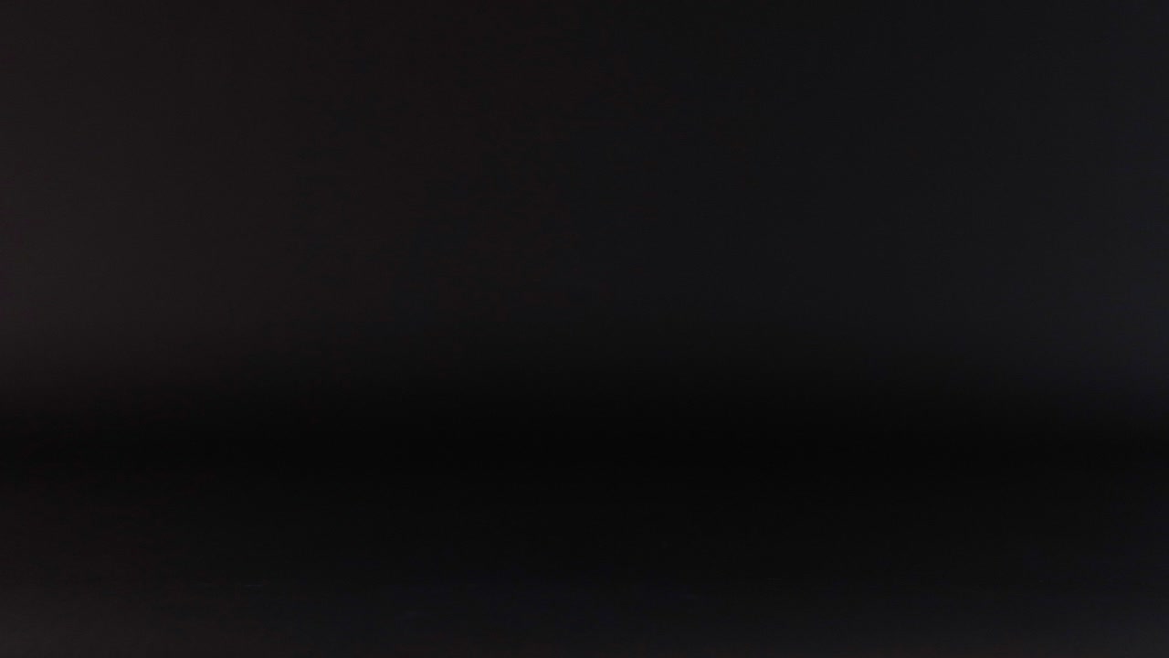 una pelota de cricket rodando a través de una superficie oscura