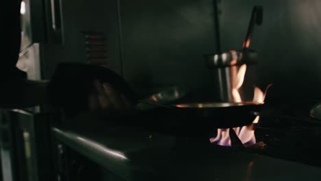 chef using flaming saucepan on stovetop