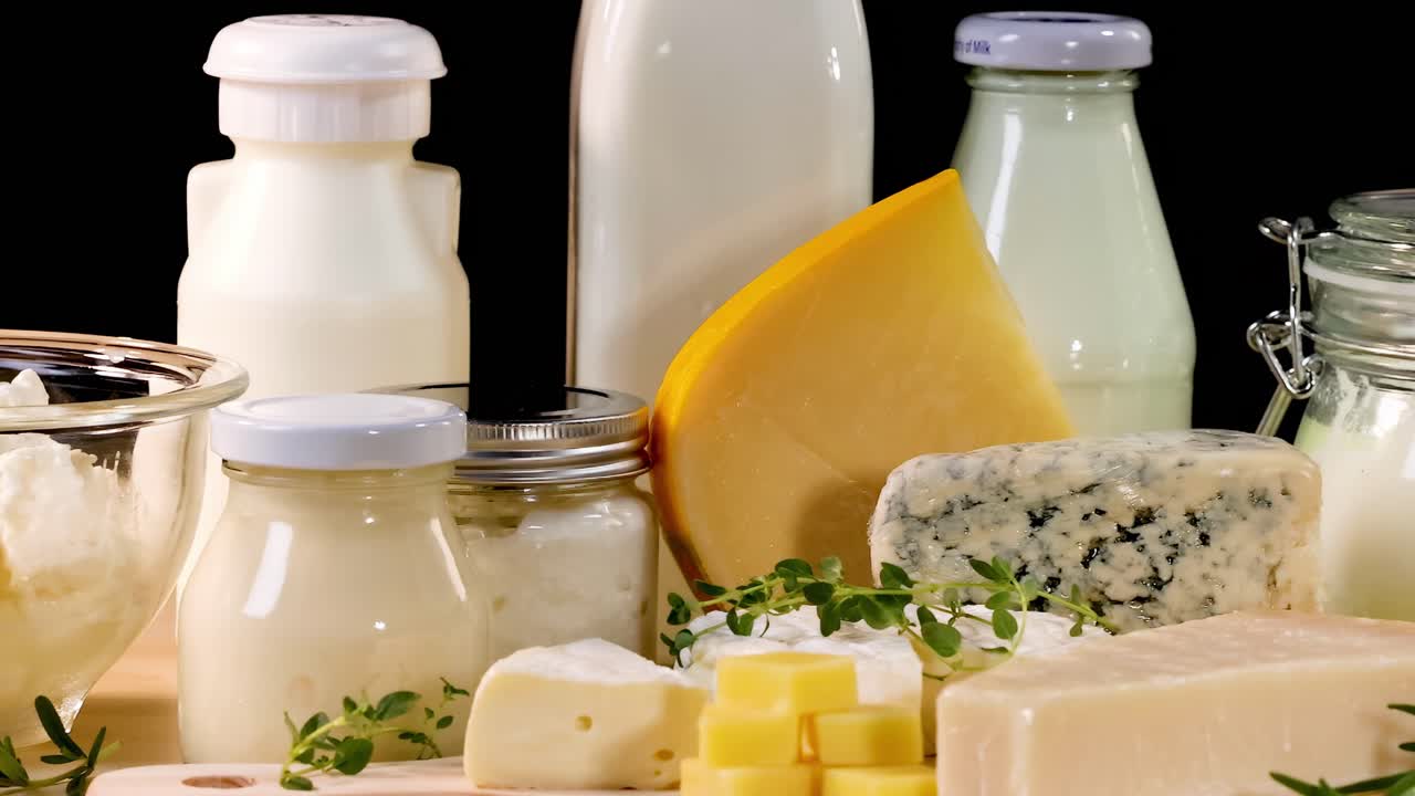 A variety of dairy items including cheese, milk, and butter arranged on a wooden table.