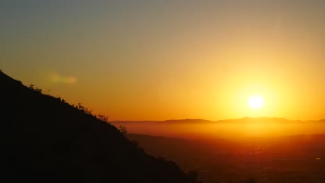 Hermosa-Puesta-De-Sol-Dorada-Con-Niebla-En-La-Cima-De-La-Montaña,-Townsville,-Colinas-Del-Castillo,-Australia