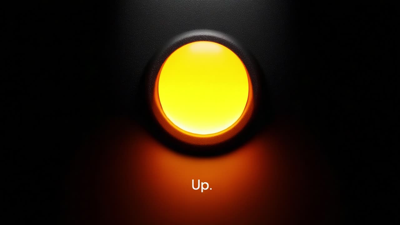 A close-up view of a glowing button marked 'Up' displayed against a dark background, capturing the transition in color and intensity across two frames of a video