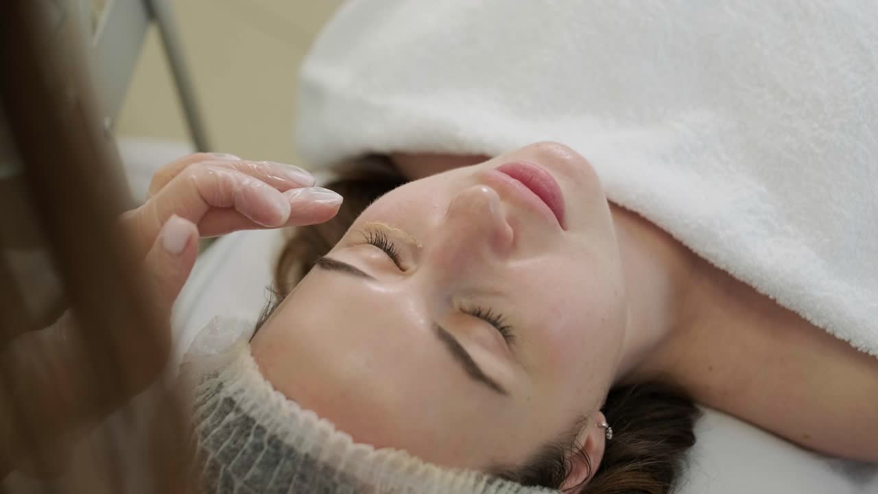 미용 전문가가 얼굴 치료와 얼굴 마스크를 적용합니다.