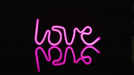 Animation-of-pink-neon-lights-forming-love-text-over-black-background