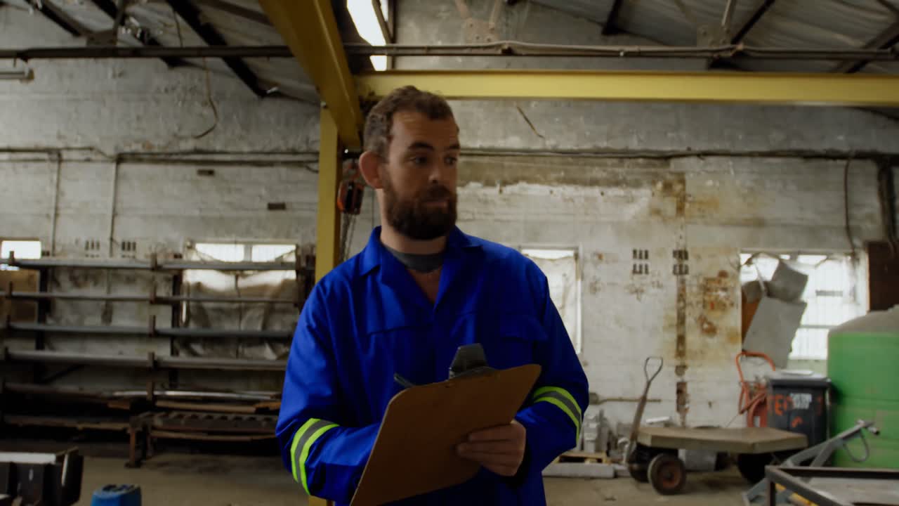 Fabbro che scrive su blocco appunti in officina 4k