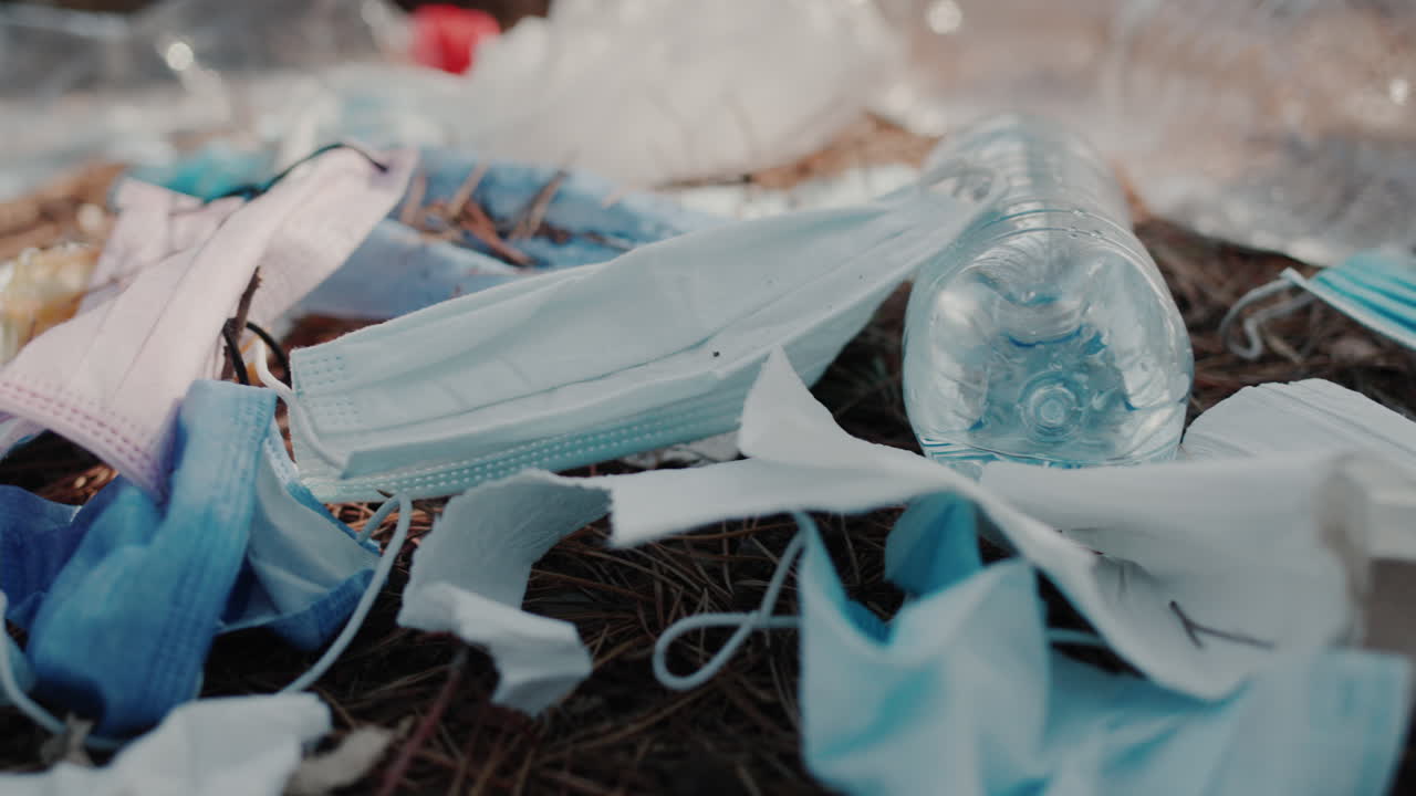 의료용 마스크와 플라스틱의 파편이 숲의 바닥에 놓여 있다