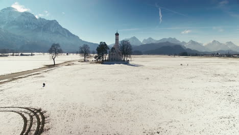 Clip-Aéreo-De-Una-Iglesia-En-Medio-De-Grandes-Campos,-Con-Montañas-Al-Fondo,-Durante-El-Invierno