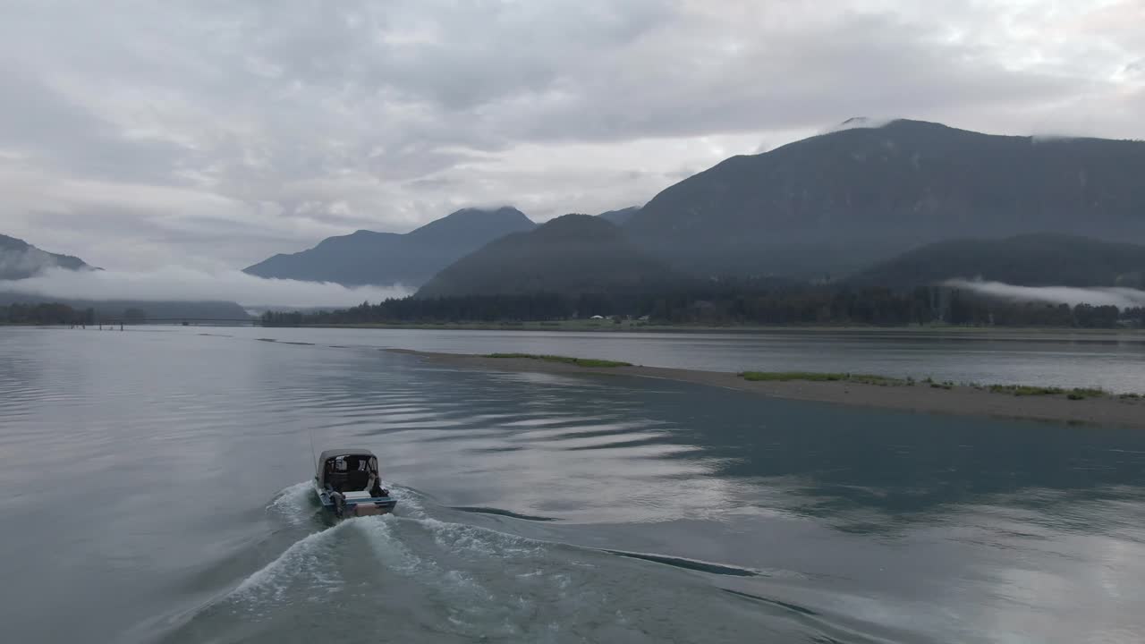 강을 따라 천천히 움직이는 제트 보트의 4k 드론 영상
