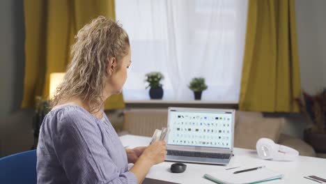 mujer de comercio electrónico tomando notas siguiendo nuevos productos en línea.