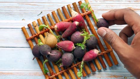 assortment of colorful small radishes on bamboo mat