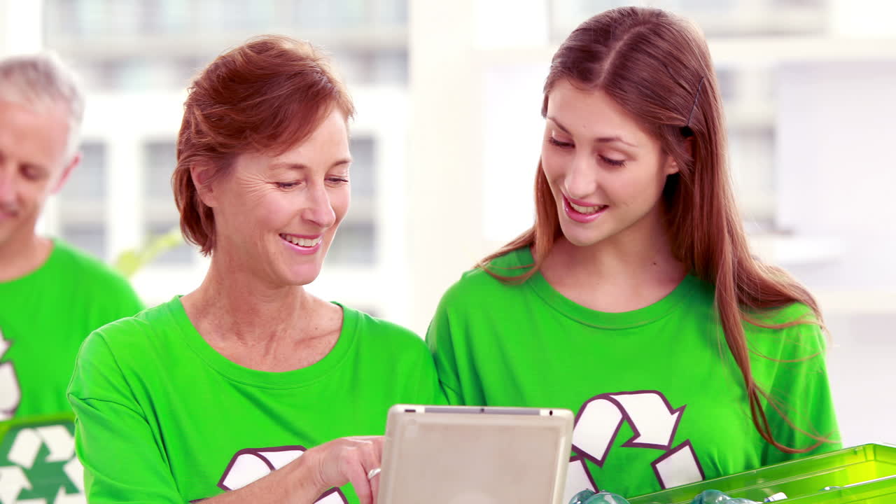 Happy volunteer friends using tablet pc