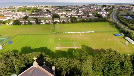 kids are playing cricket behind the church aerial birds eye view drone shot