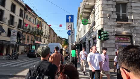 personas caminando e interactuando en una calle de milán