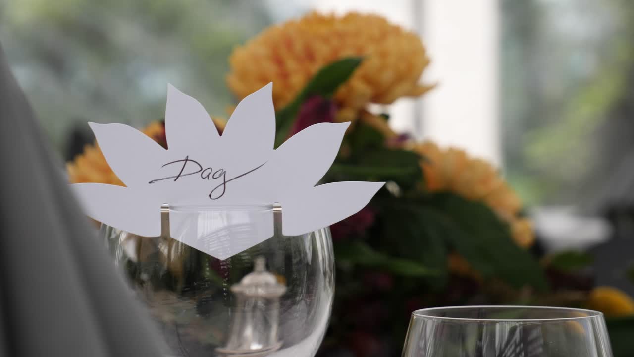 Teble setting before the start of a celebration dinner event such as a wedding or anniversary with flower centerpeice