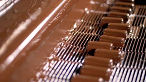 close-up view on process of poured candy bars with liquid chocolate.