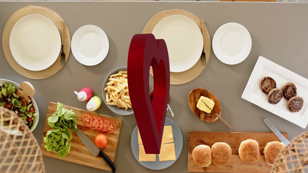 On loop start rotating red hollow heart pivoting above table, framing fries and showing meal layout
