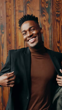 smiling man posing confidently in blazer and turtleneck