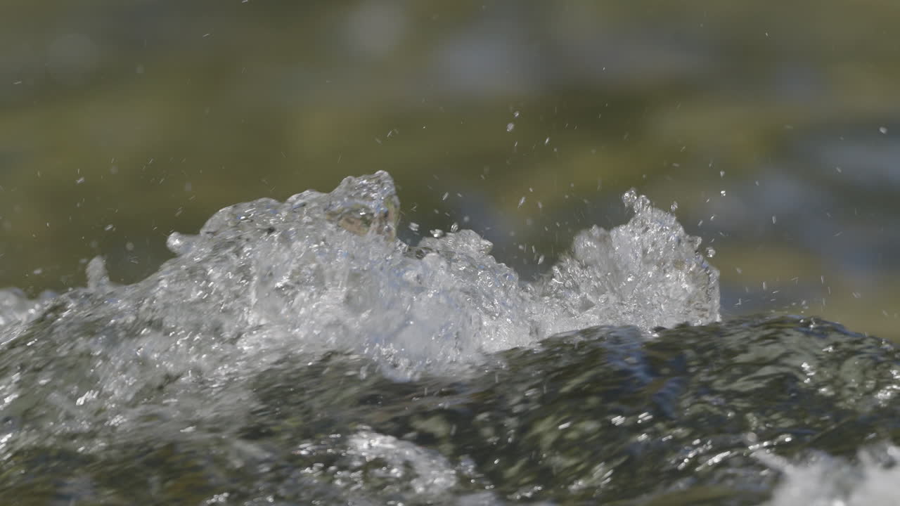 Vand i en flod, der bevæger sig hurtigt i slowmotion og makro