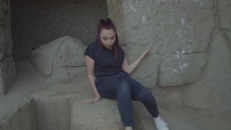 woman dancing while creep walking on an ancient designed rock wall setup