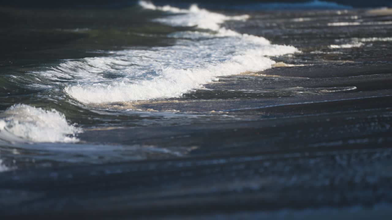 las olas ruedan lentamente en las aguas poco profundas de la playa de arena en ersfjord