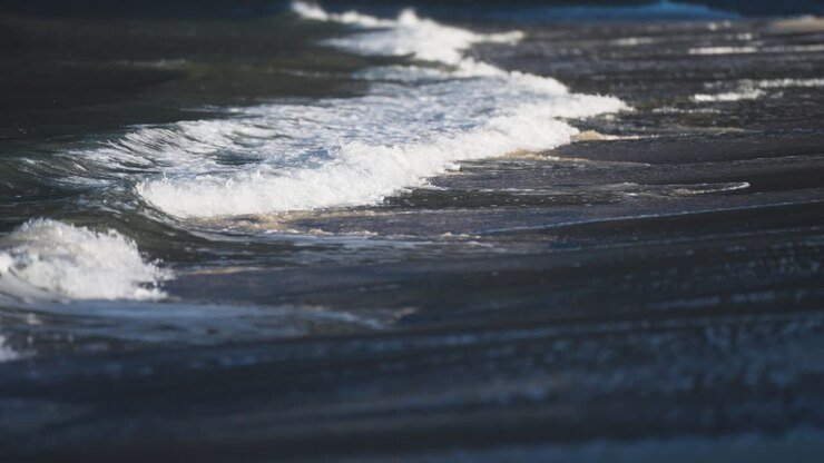 Waves roll slowly on the shallows of the sandy beach in Ersfjord