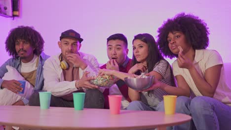 friends enjoying a movie night with snacks on the couch