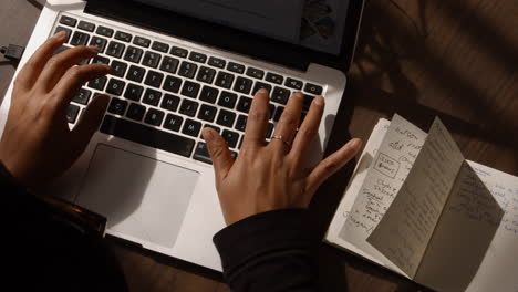 a woman types on her keyboard on her laptop computer as she works from home