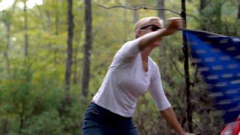 pretty blonde woman with sunglasses dances with an american flag