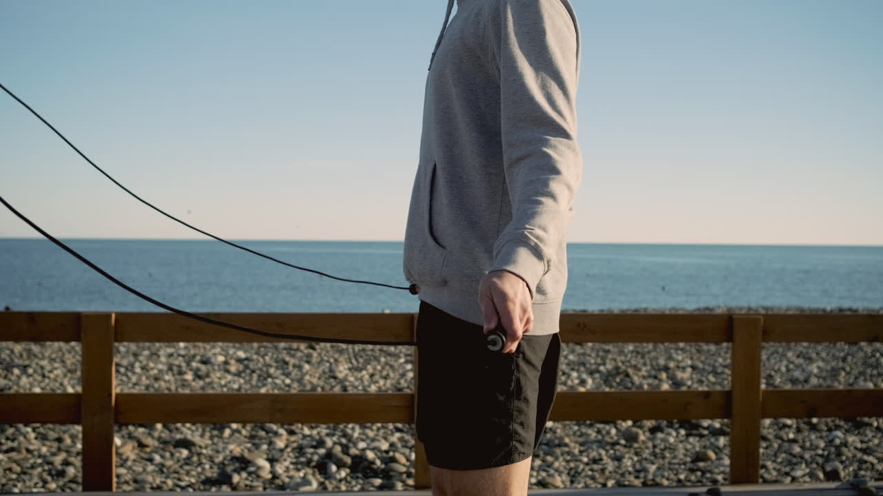 해변에서 로프를 뛰어넘는 남자