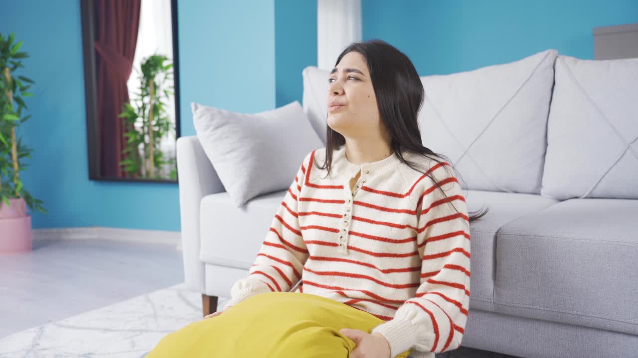 우울하고 불행한 젊은 여성이 집에서 신경 ⁇ 약을  ⁇ 고 있습니다.