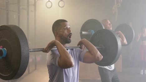 diverse male group lifting barbells, free weight training at gym, in slow motion