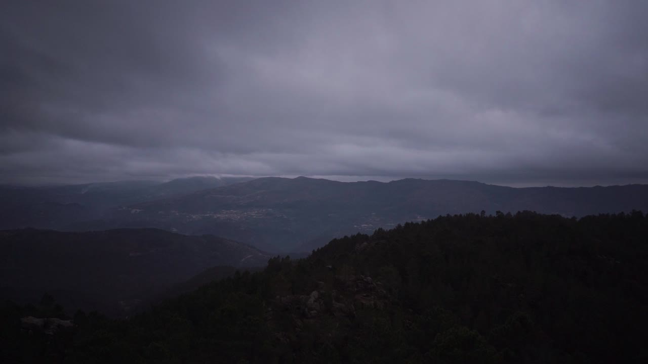 Montanhas sombrias ao amanhecer nublado, vista panorâmica.