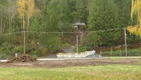 conducción de automóviles pasa por la carretera de montaña con madera destrozada y árboles apilados en la carretera después de una inundación devastadora causada por lluvias torrenciales extremas en abbotsford, columbia británica, canadá - noviembre de 2021