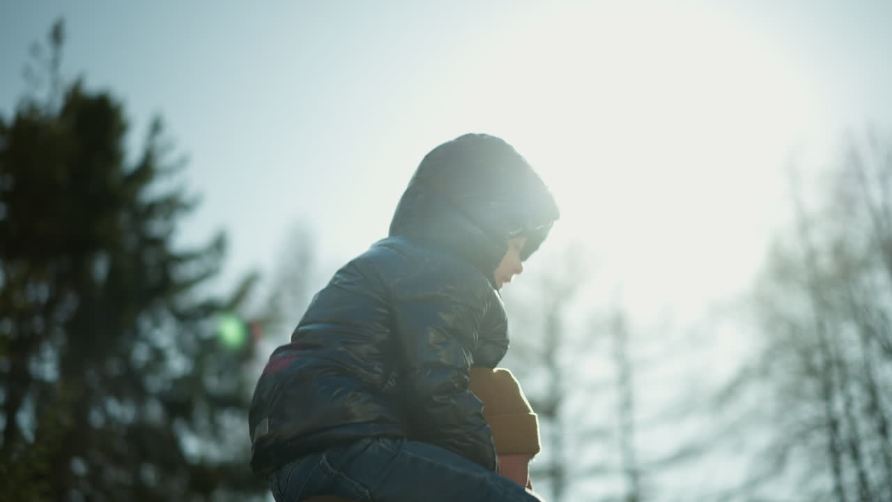 un momento de alegría de un padre llevando a su sonriente hijo en sus hombros mientras juegan juntos al aire libre. la luz del sol se refleja hermosamente en ellos