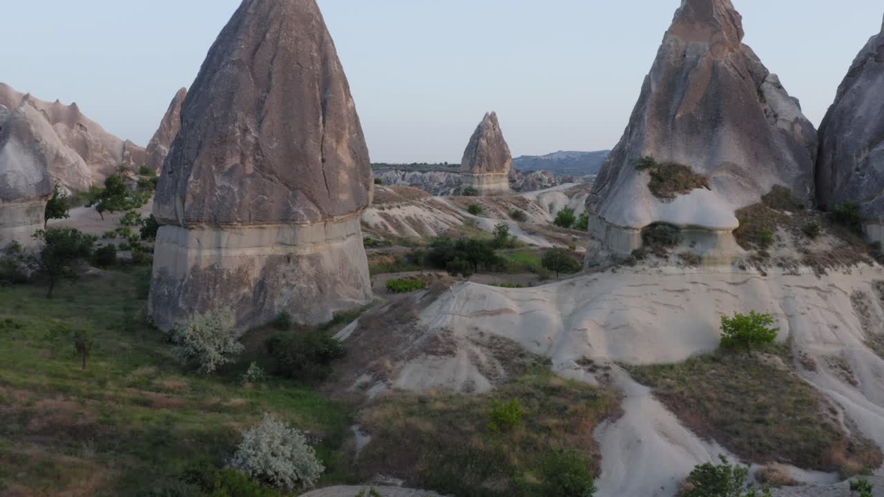 máy bay không người lái bay ra khỏi cận cảnh đến trung bình của các hình thành đá câu chuyện cổ tích trong các cánh đồng cỏ cappadocia thổ nhĩ kỳ