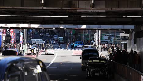 cars and people crossing an urban intersection