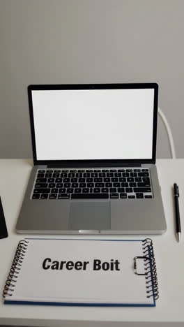laptop, notebook, and career planning materials on a desk