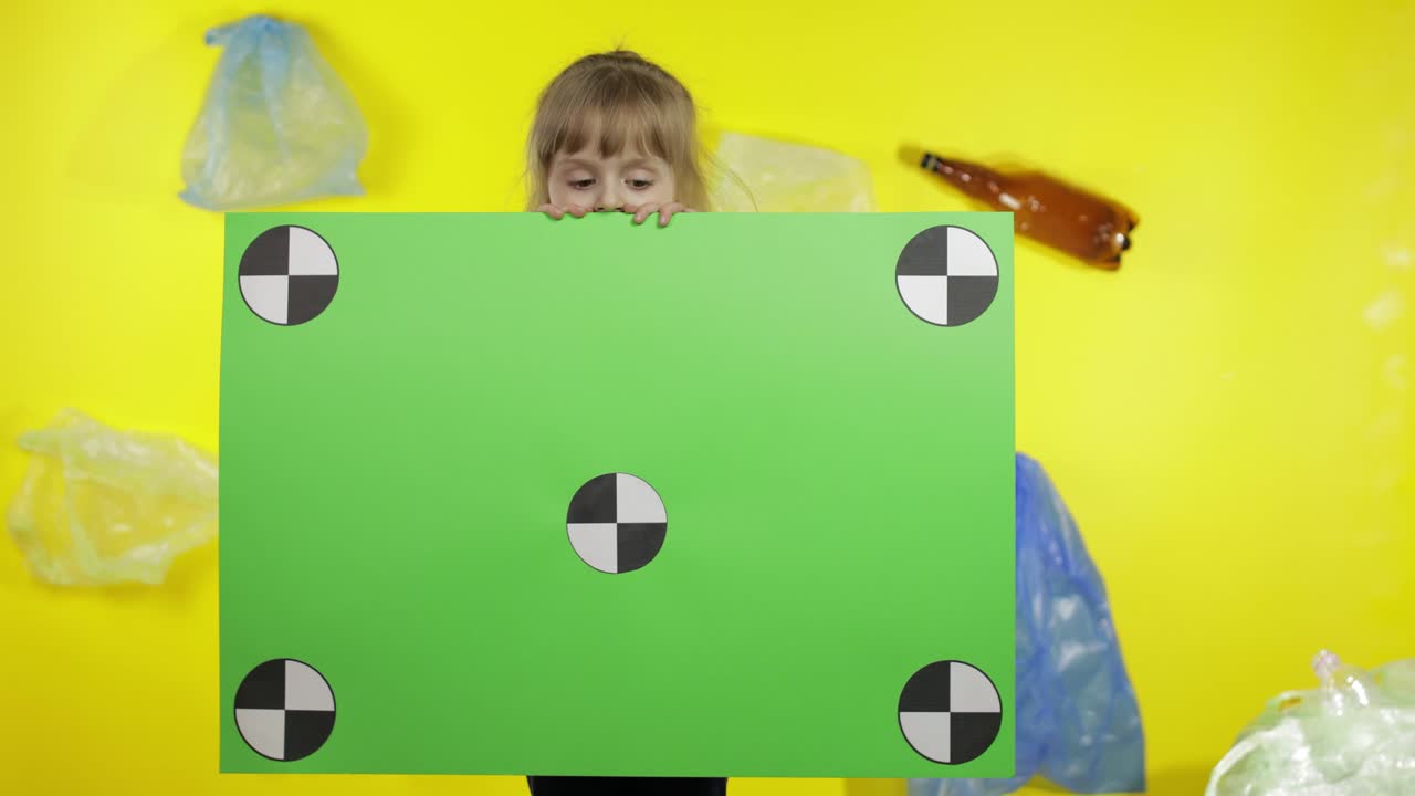 Ragazza attivista che tiene un poster chroma key con punti di tracciamento. Inquinamento ambientale da plastica e rifiuti