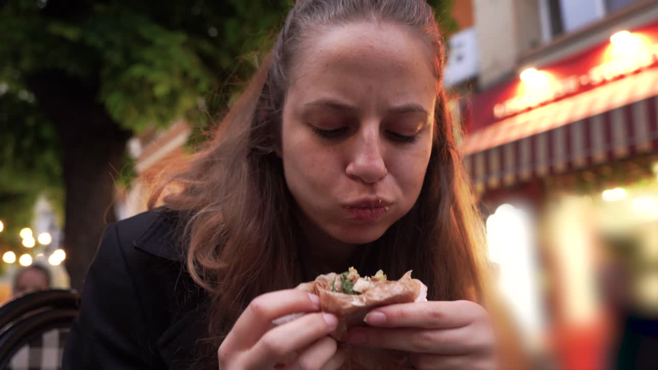 A girl enjoys a classic falafel duner at a local food stand in central Sofia perfect for food and travel content