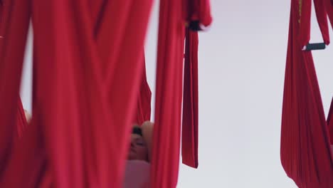 women lie and swing resting in anti-gravity yoga hammocks