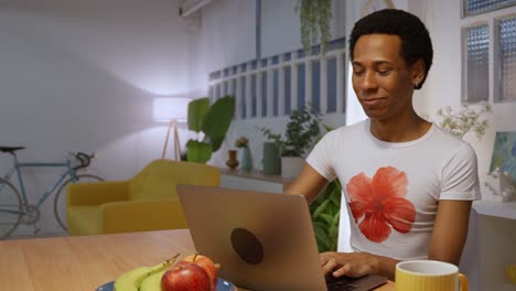 hombre trabajando en una computadora portátil en casa