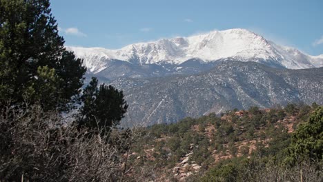 snow-capped pikes peak towering over the landscape, with a clear blue sky in colorado springs