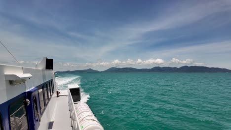 sunny ferry ride between tropical islands in thailand. clear blue skies and turquoise waters create a serene journey