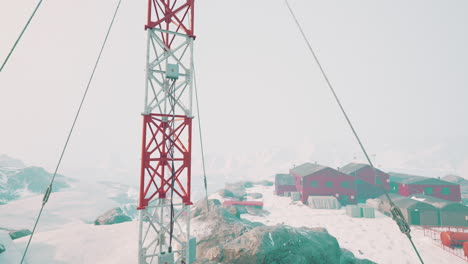 una torre de comunicación roja y blanca de pie en el paisaje cubierto de nieve de la antártida