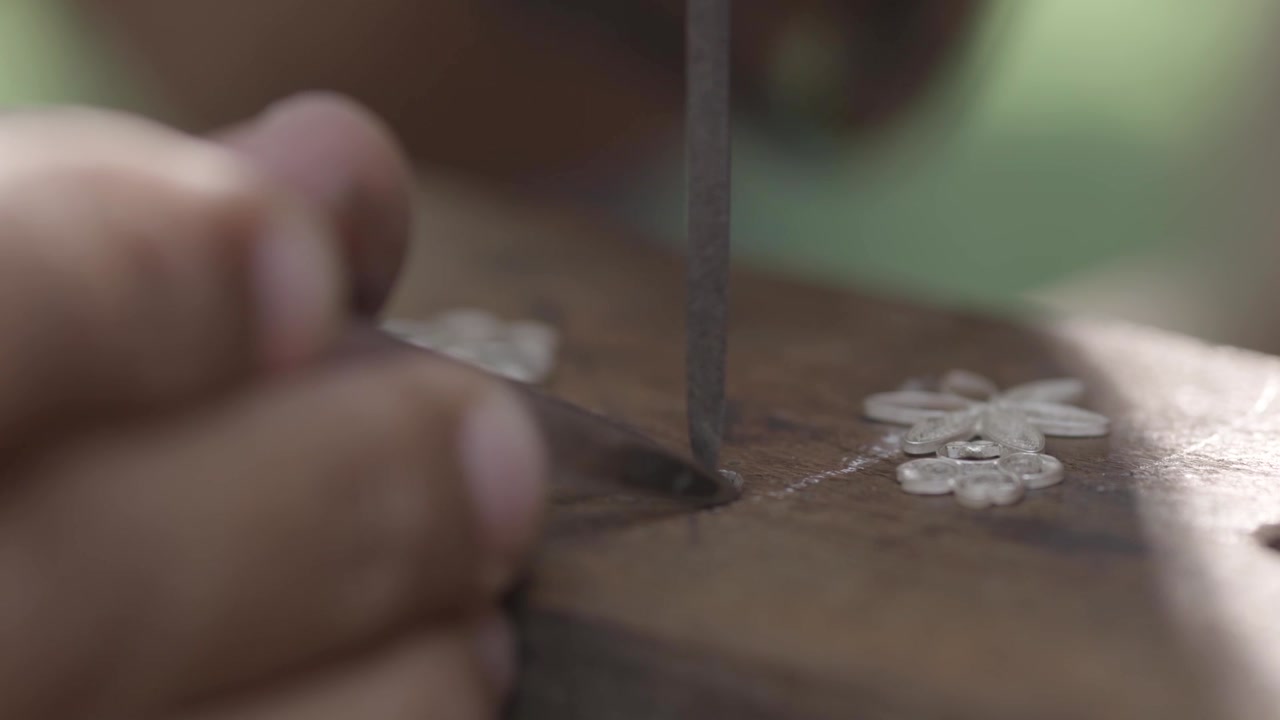 Hands shape delicate wood grain with focused precision. Fingers guide tool, carving intricate floral patterns. Craftsperson's patience shines in each careful stroke. Ideal for artisan, craftsmanship