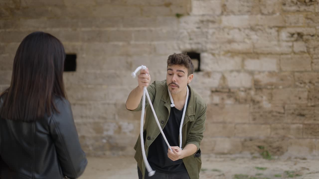 Magician performing a rope trick outdoors