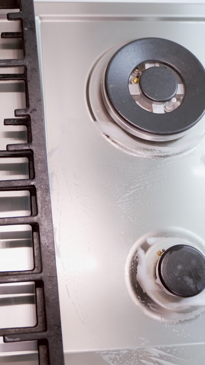 Cleaning of gas cooker, close up. Close up of cleaning gas stove in the kitchen