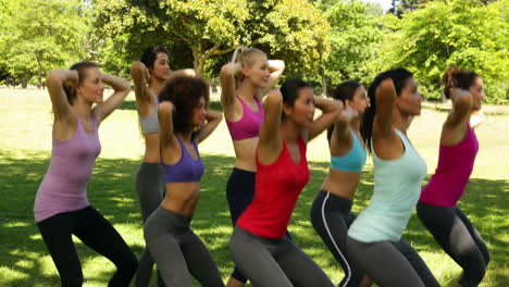 fitness class doing squat sequence together