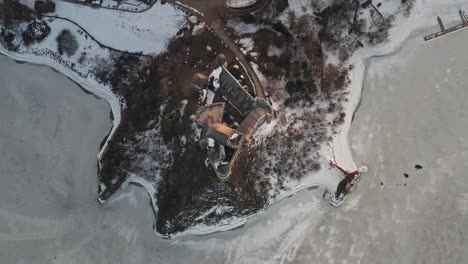 Aerial-top-down-over-Niedzica-Castle-in-winter-season-and-frozen-lake