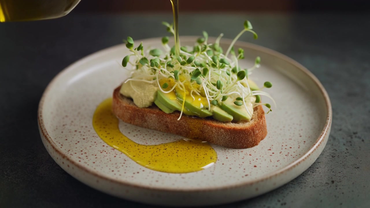 Olivenolie hældes over frisk avocadotoast